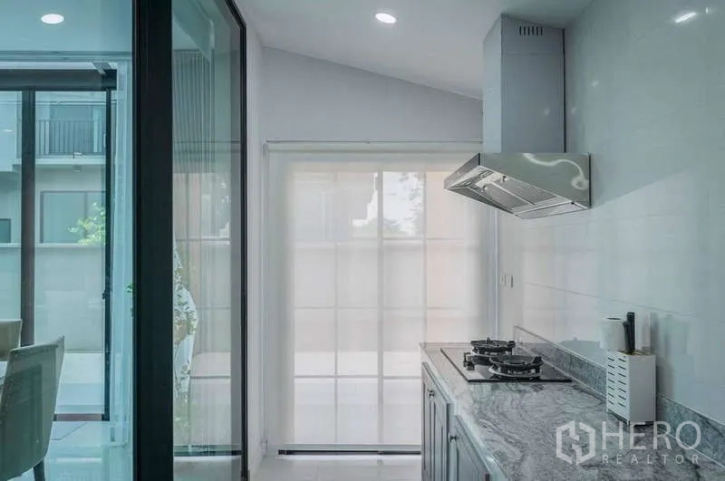 Detached House for rent in Bang Phli, Samut Prakan - Enclosed kitchen with granite countertop, gas hob and stainless-steel hood.