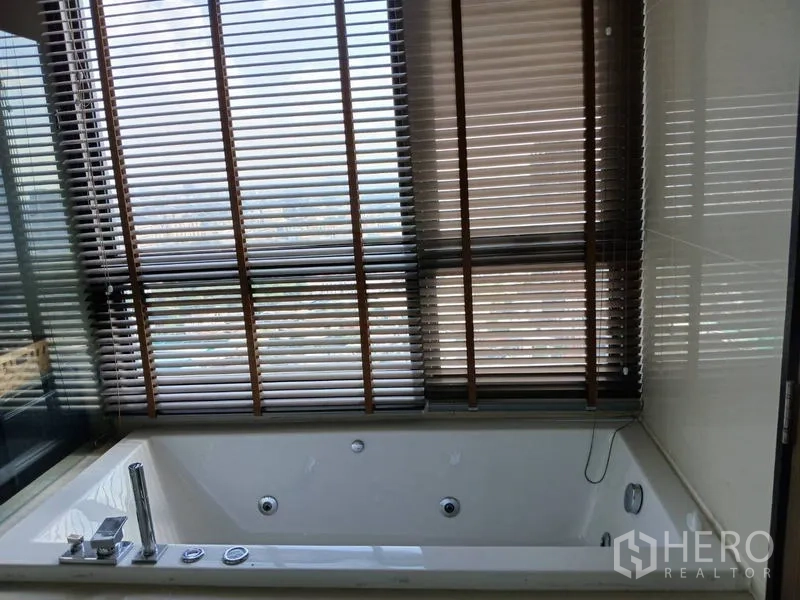 คอนโด ให้เช่า - ห้องน้ำมีอ่างอาบน้ำติดหน้าต่างพร้อมมู่ลี่ มองเห็นวิวเมือง