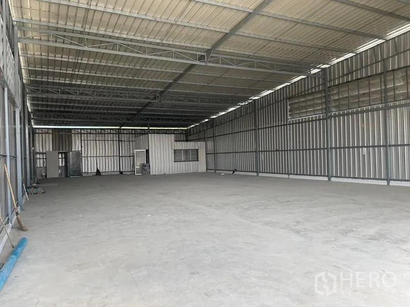Warehouse for rent in Min Buri, Bangkok - Spacious open-plan warehouse interior with high steel truss roof and concrete floor.