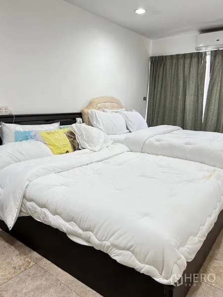 Condominium for rent in Ratchathewi, Bangkok - Close view of twin beds with soft duvets and full-height curtains.