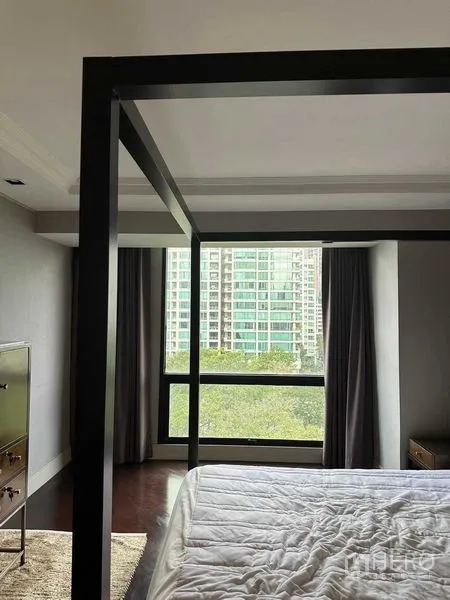 Condominium for sale in Pathum Wan, Bangkok - Bedroom with four‑poster frame and large window overlooking city skyline and treetops.