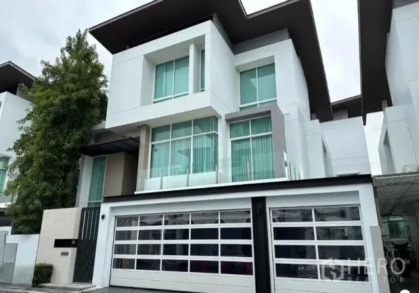 Detached House for sale in Suan Luang, Bangkok - Contemporary three-storey facade with large windows and sliding gate.