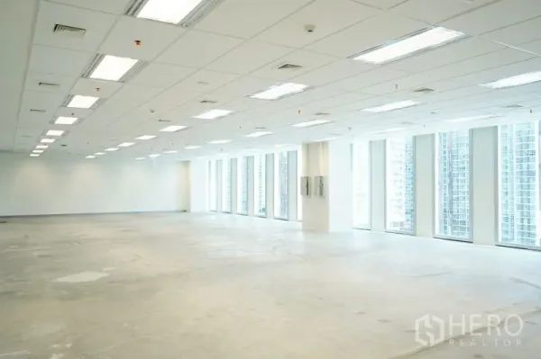 办公空间 出租在Bang Na, Bangkok - 宽阔楼层平面，线性灯与全高玻璃窗在一侧排布。