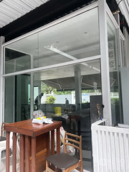 零售空间 出租在Khlong Toei, Bangkok - 玻璃立面店铺入口，前方有雨棚与简易座位区
