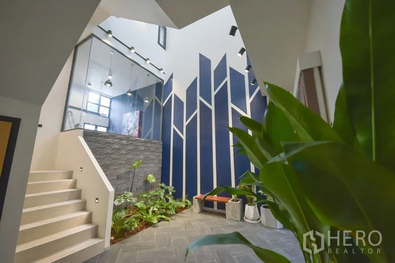 Home Office for rent or sale - Atrium lobby with indoor garden, skylights and striking blue accent wall.