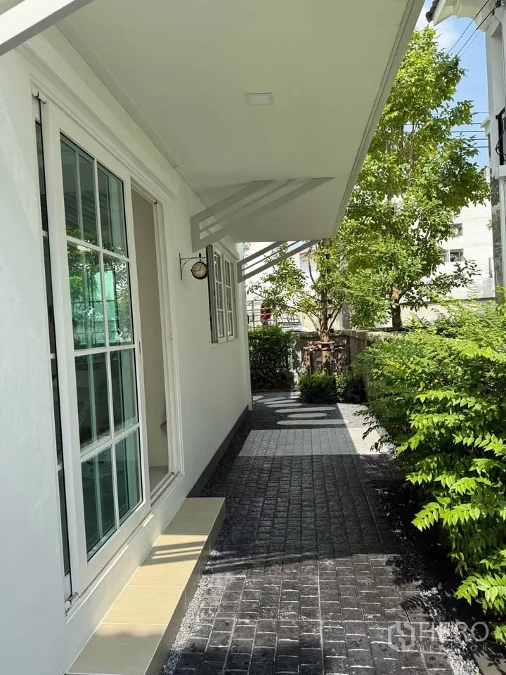 บ้านแฝด for rent in Mueang Samut Prakan, Samut Prakan - ลานข้างบ้านมีประตูกระจกบานเลื่อน กันสาด และพุ่มไม้จัดสวน
