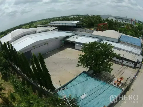 货栈 出租在Pak Kret, Nonthaburi - 鸟瞰大型仓库园区，宽阔混凝土场地与金属屋顶，位于Pak Kret暖武里。
