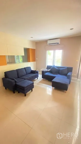 独立式住宅 出租 - 带空调的客厅，蓝色沙发，亮面地砖，大窗采光充足。