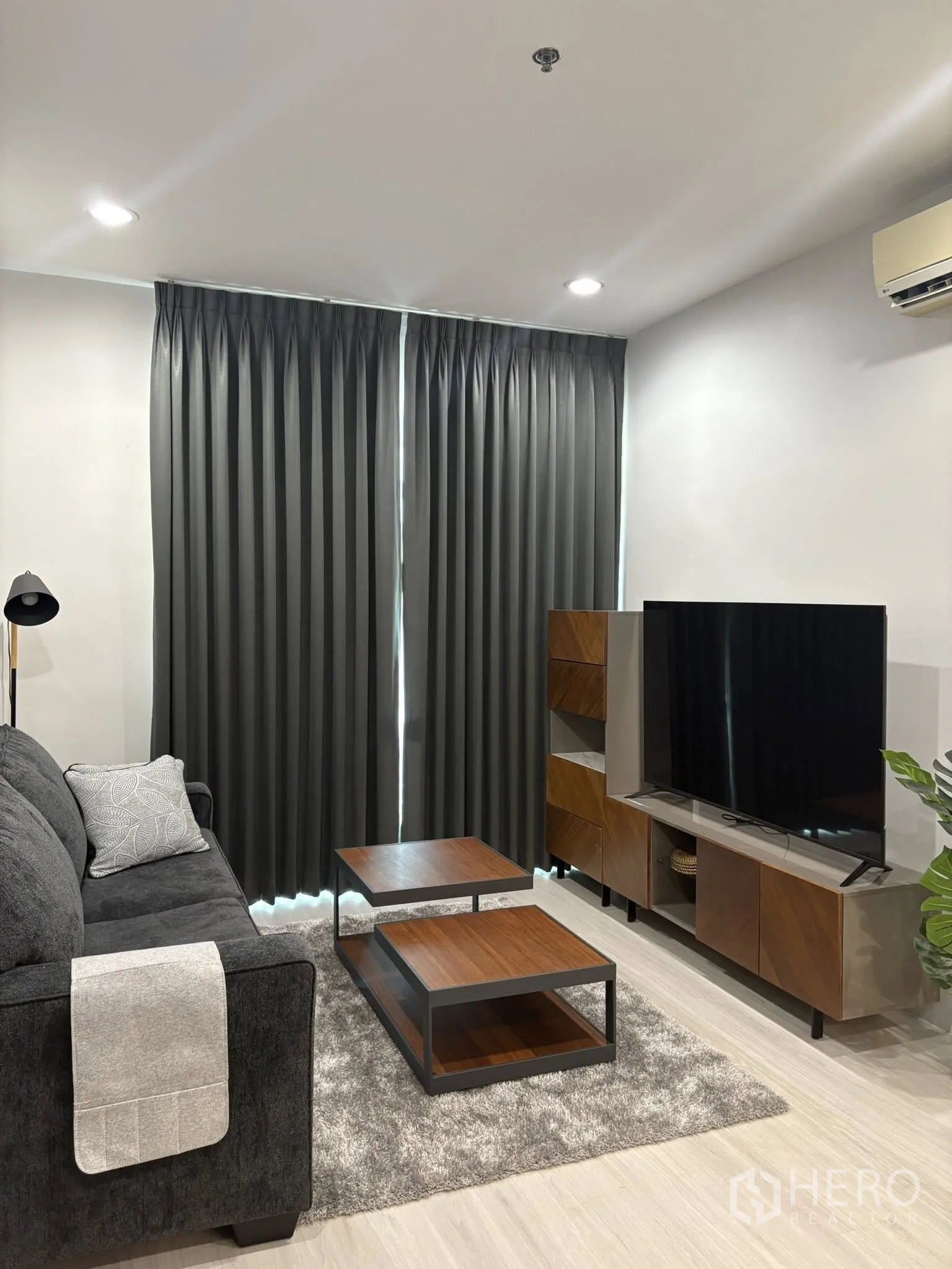 คอนโด for rent in Ratchathewi, Bangkok - ห้องนั่งเล่นอบอุ่น โซฟาสีเข้ม พรมขนเฟอร์ ตู้ทีวี และโต๊ะกาแฟไม้