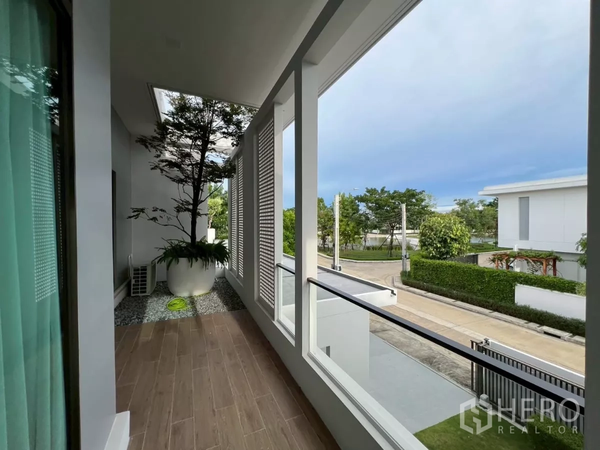 Detached House for rent in Samut Prakan - Covered balcony with planter and privacy screens overlooking the street.