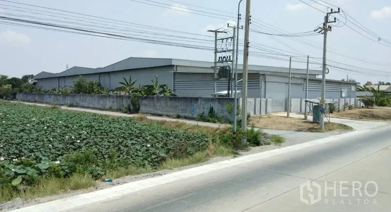 คลังสินค้า ให้เช่าในPathum Thani - พื้นที่โกดังภายในรั้วติดถนนหลัก พร้อมกำแพงรอบและเสาไฟฟ้า