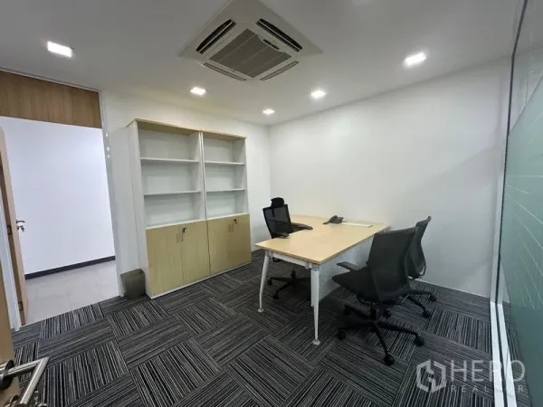 Office Space for rent - Private manager’s office with desk, shelving cabinet, carpet tiles, and ceiling cassette AC.