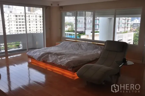 คอนโด ให้เช่าในKhlong Toei, Bangkok - ห้องนอนใหญ่กว้าง เตียงแพลตฟอร์มมีไฟใต้เตียง โซฟาเดย์เบด พื้นไม้ และวิวเมืองพาโนรามา