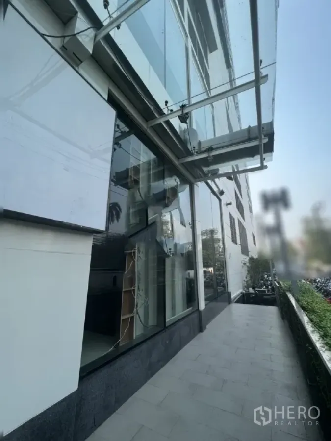 零售空间 出租在Watthana, Bangkok - 临街零售铺面，整面落地玻璃外墙与遮雨棚，旁有宽阔人行道。