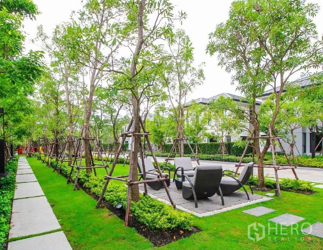 Detached House for rent or sale in Wang Thonglang, Bangkok - Landscaped garden with walkway, lawn and outdoor seating among trees.