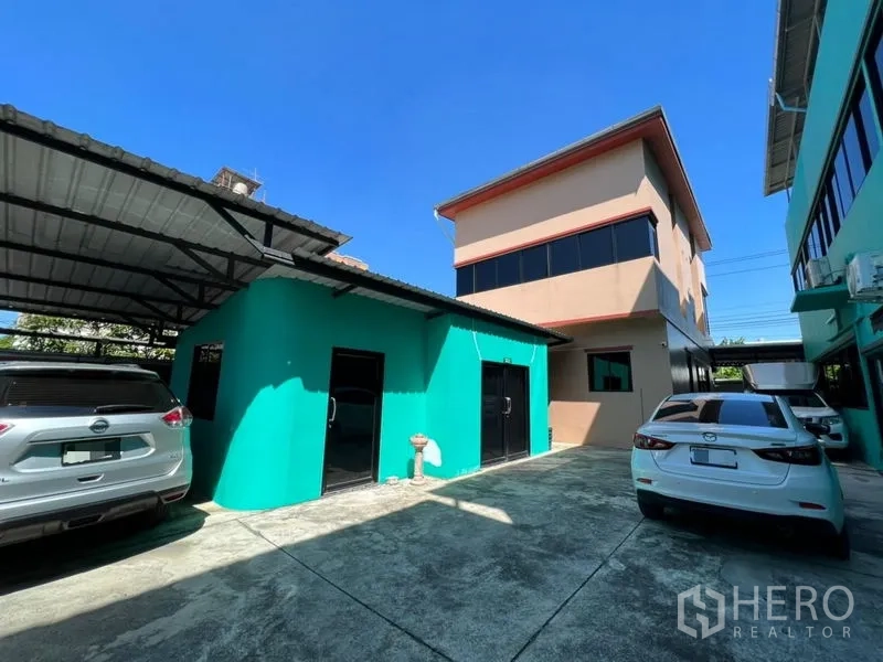 工厂 出售在Wang Thonglang, Bangkok - 院内混凝土地坪，带雨棚车位与薄荷绿附属建筑。
