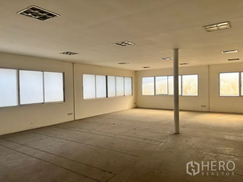 Warehouse for rent in Suan Luang, Bangkok - Bright open workspace with multiple windows and a central column suitable for team areas.