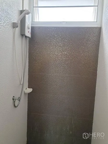 Detached House for rent in Khlong Toei, Bangkok - Shower area with water heater below a small window and textured wall.