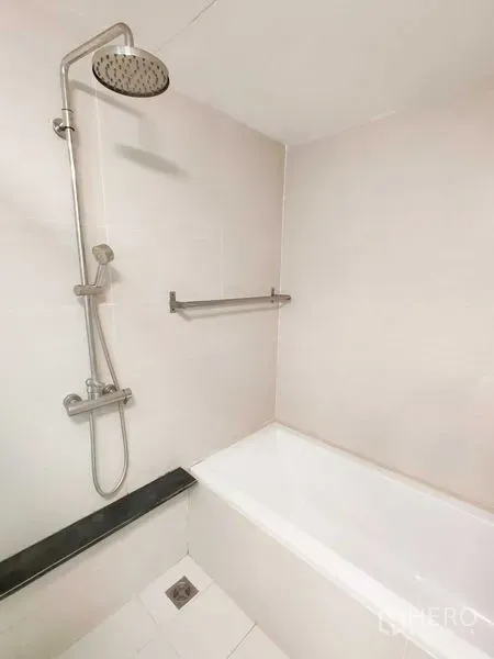 คอนโด ให้เช่าในKhlong Toei, Bangkok - อ่างอาบน้ำสีขาวพร้อมฝักบัวเรนชาวเวอร์และราวแขวนผ้าในห้องน้ำปูกระเบื้อง