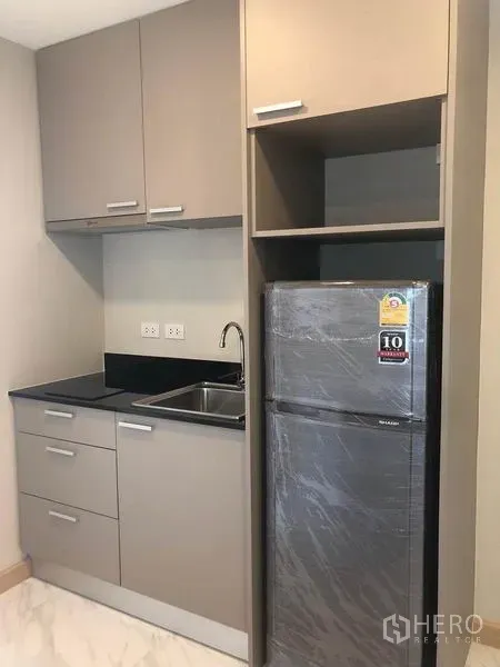 คอนโด for ในWatthana, Bangkok - มุมครัวกะทัดรัดพร้อมอ่างล้างจาน เตาไฟฟ้า ตู้เก็บของ และตู้เย็นทรงสูง