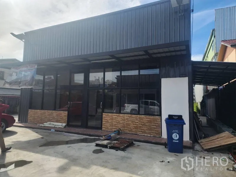 Warehouse for rent in Suan Luang, Bangkok - Modern warehouse exterior with full-height glass frontage, metal cladding and a paved parking apron.