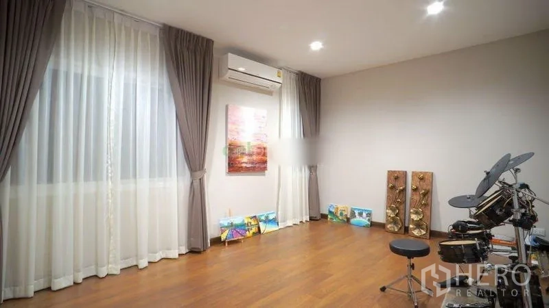 Detached House for rent or sale in Bang Phli, Samut Prakan - Multi-purpose room with wood floors, large windows and a drum set.