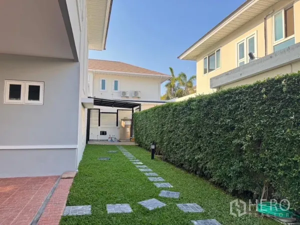 บ้าน ให้เช่าหรือขายในPrawet, Bangkok - ลานข้างบ้าน สนามหญ้าแนวยาว แนวรั้วต้นไม้ และทางเดินไปยังโซนบริการ