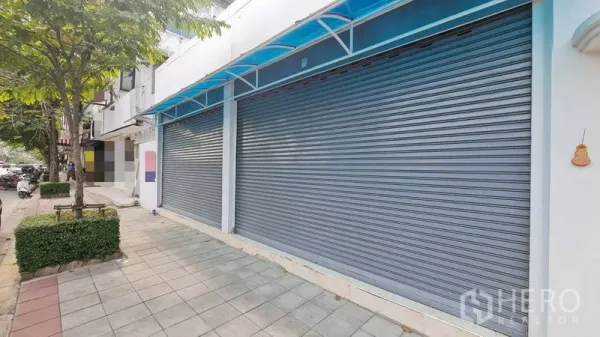 Shophouse for rent - Shophouse exterior with twin roller shutters under blue awning and wide sidewalk