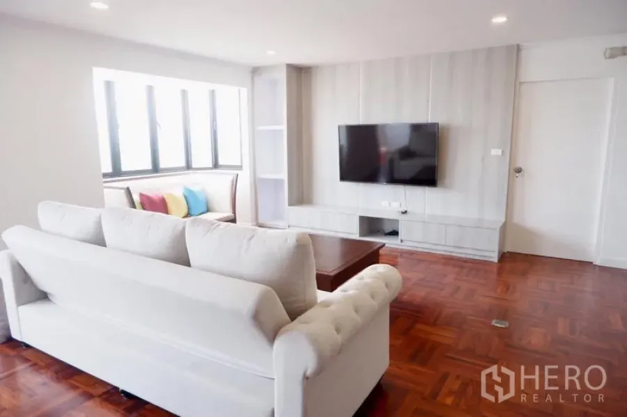 公寓 出租在Khlong Toei, Bangkok - 客厅角度，白沙发对着电视墙，旁有飘窗小沙发