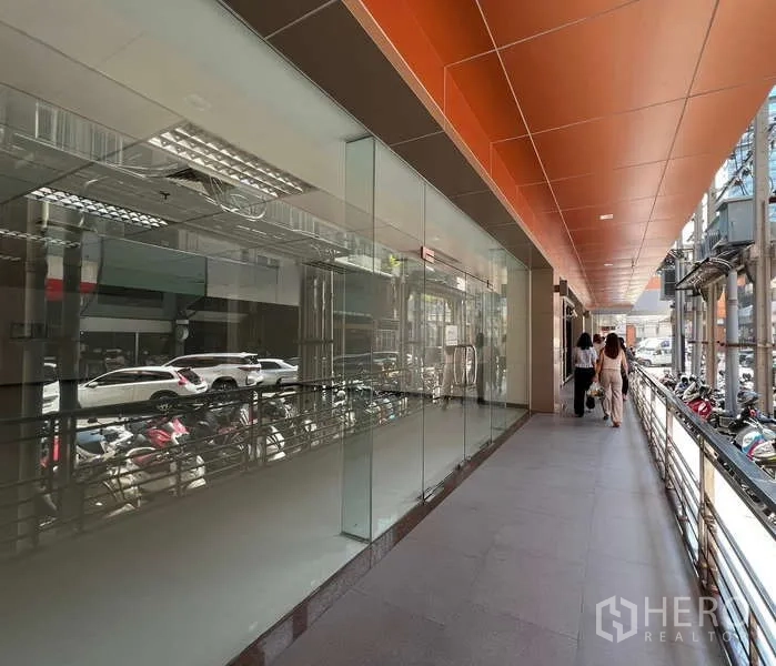 零售空间 出租在Pathum Wan, Bangkok - 有顶走道旁的玻璃店面与橙色天花板，位于曼谷市中心。