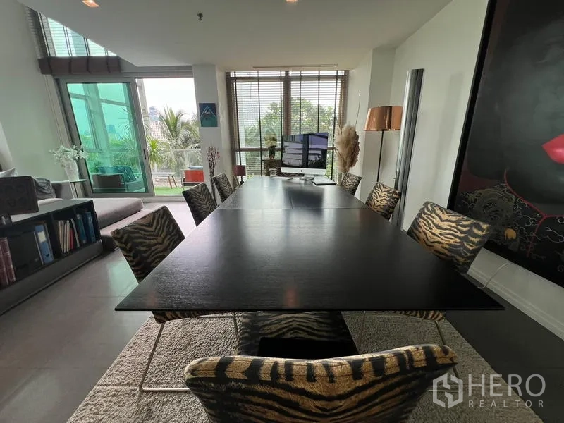 คอนโด ขายในKhlong San, Bangkok - โต๊ะอาหารยาวเก้าอี้ลายม้าลายริมหน้าต่าง พร้อมวิวสีเขียว