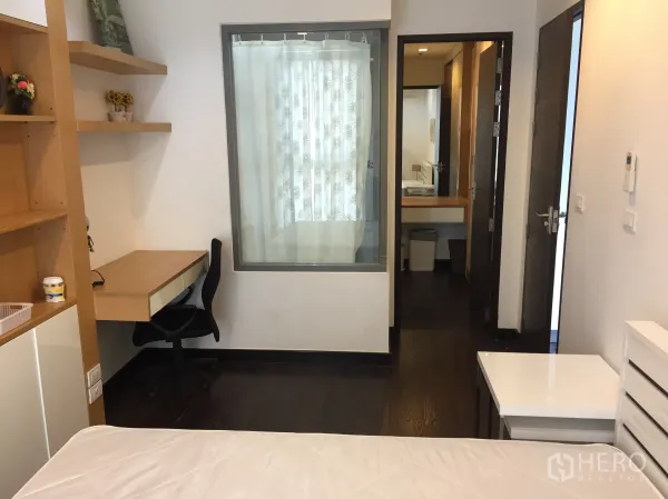 คอนโด ให้เช่าในRatchathewi, Bangkok - ห้องนอนพร้อมโต๊ะทำงานและชั้นวางบิลต์อิน มีฉากกั้นกระจกและพื้นไม้สีเข้ม