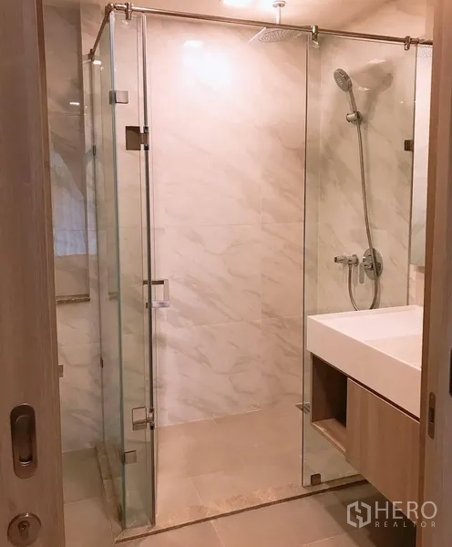 公寓 出租在Watthana, Bangkok - 浴室配无框玻璃淋浴间、雨淋花洒和大尺寸台盆。