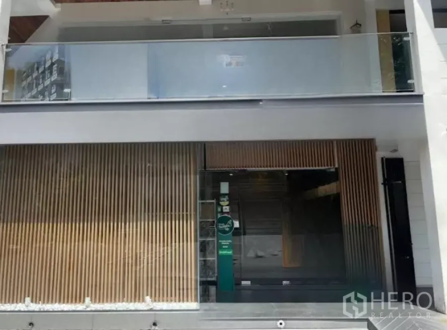 零售空间 出租在Watthana, Bangkok - 通罗区现代店面，玻璃大门与木质格栅立面，楼上设阳台