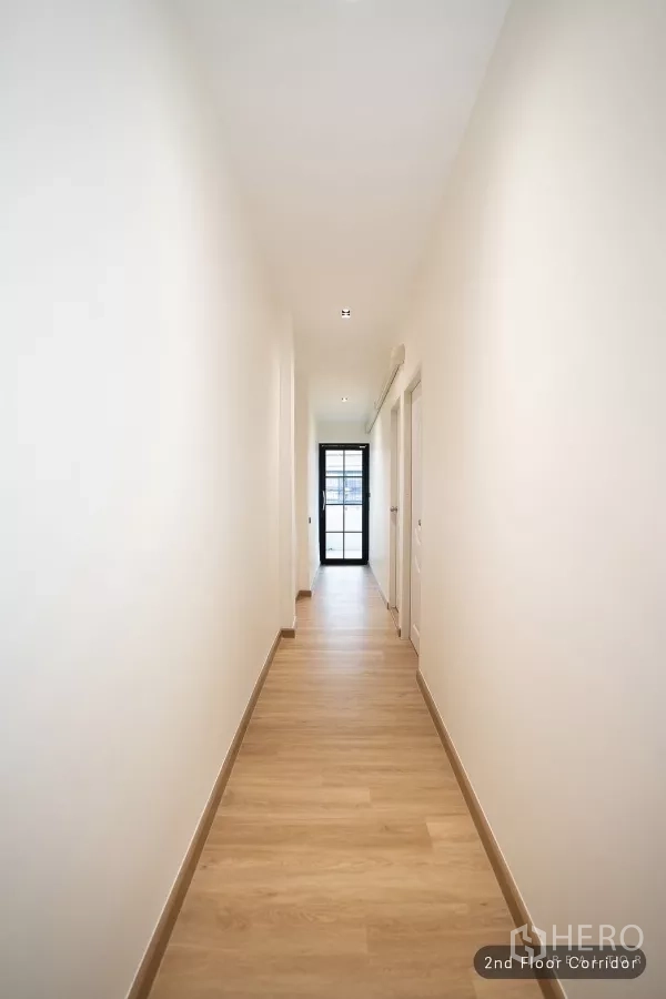 ทาวน์เฮาส์ ให้เช่าในHuai Khwang, Bangkok - โถงทางเดินชั้นสองพื้นไม้พร้อมประตูกระจกปลายทาง