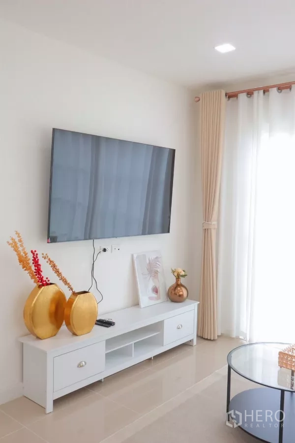 Detached House for rent in Bang Phli, Samut Prakan - TV feature wall with white console and gold decor next to sheer drapes.