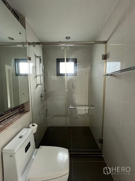 Detached House for rent in Bang Kapi, Bangkok - Compact bathroom with glass shower enclosure and toilet.