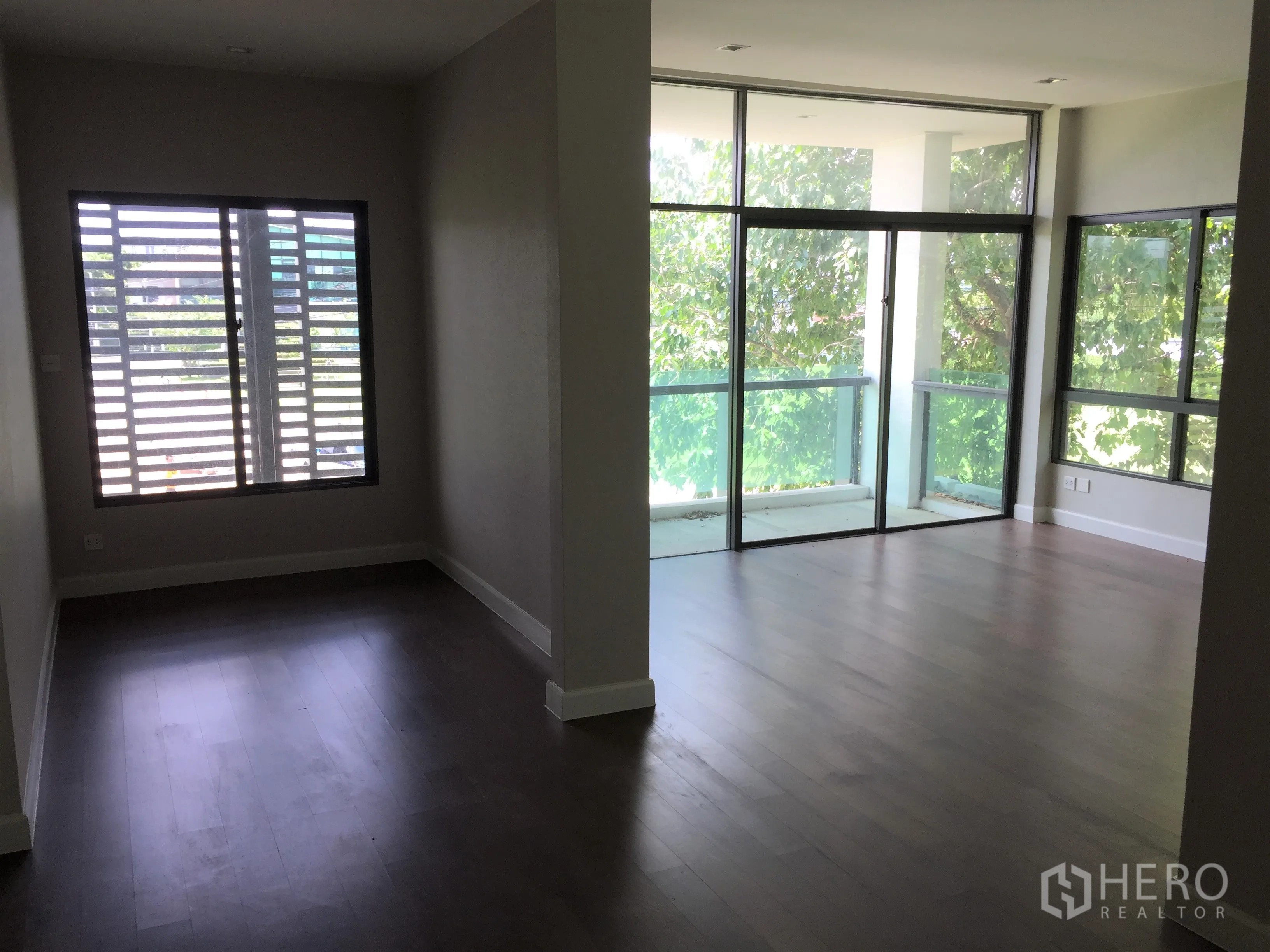 Detached House for rent or sale in Prawet, Bangkok - Upstairs family room with hardwood floors and a balcony facing mature trees.