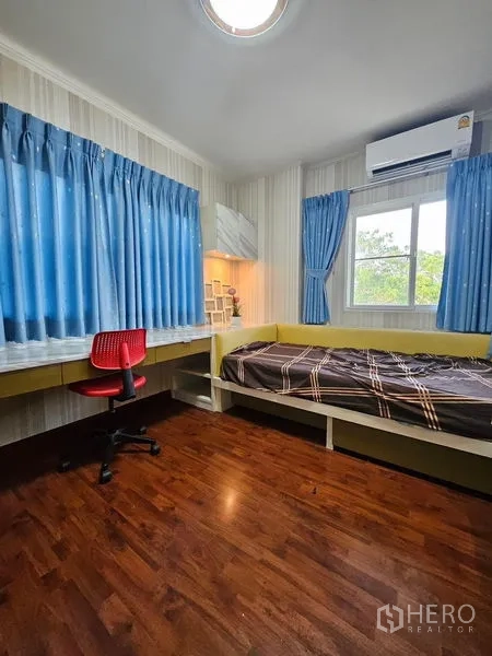 บ้าน ให้เช่า - ห้องนอนเด็กพร้อมโต๊ะทำงาน เก้าอี้สีแดง ผ้าม่านสีน้ำเงิน และเตียงเดี่ยวบิวท์อิน