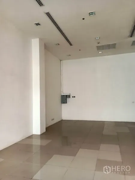 零售空间 出租在Khlong Toei, Bangkok - 空置零售室内，高挑天花、嵌灯与瓷砖地面。