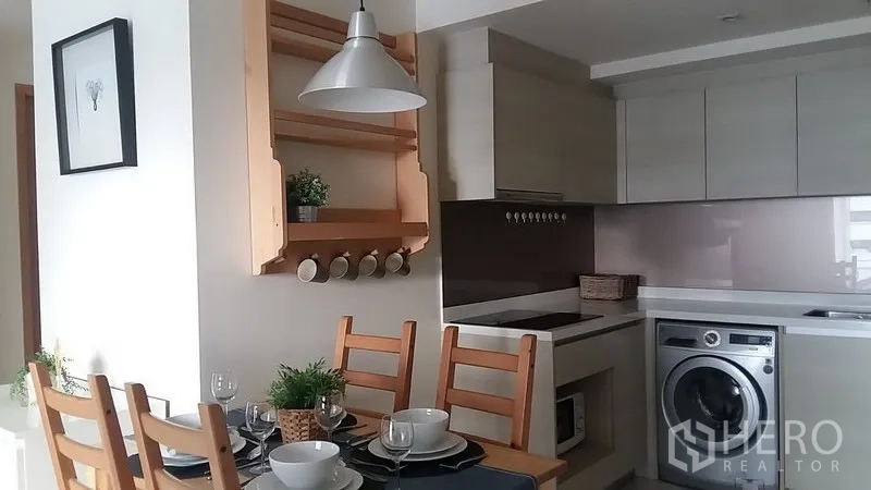 คอนโด ให้เช่าในWatthana, Bangkok - ครัวบิวท์อินพร้อมเตาไฟฟ้า ตู้เก็บของ และโคมไฟแขวนเหนือโต๊ะอาหาร