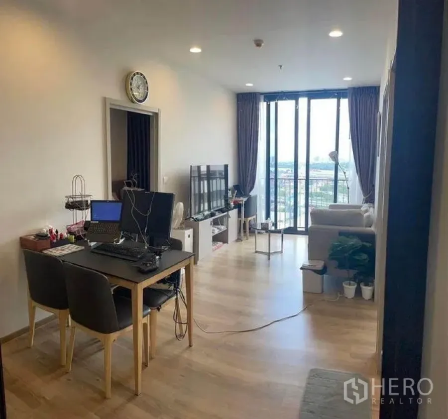 คอนโด ให้เช่าในKhlong Toei, Bangkok - โซนรับประทานอาหารและนั่งเล่นพร้อมชั้นวางทีวีและประตูกระจกบานเลื่อนออกสู่ระเบียง วิวเมือง