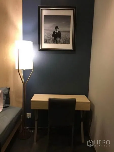 คอนโด ให้เช่าหรือขายในWatthana, Bangkok - มุมทำงานกะทัดรัดพร้อมโต๊ะ เก้าอี้ และโคมไฟตั้งพื้น ผนังสีเข้ม