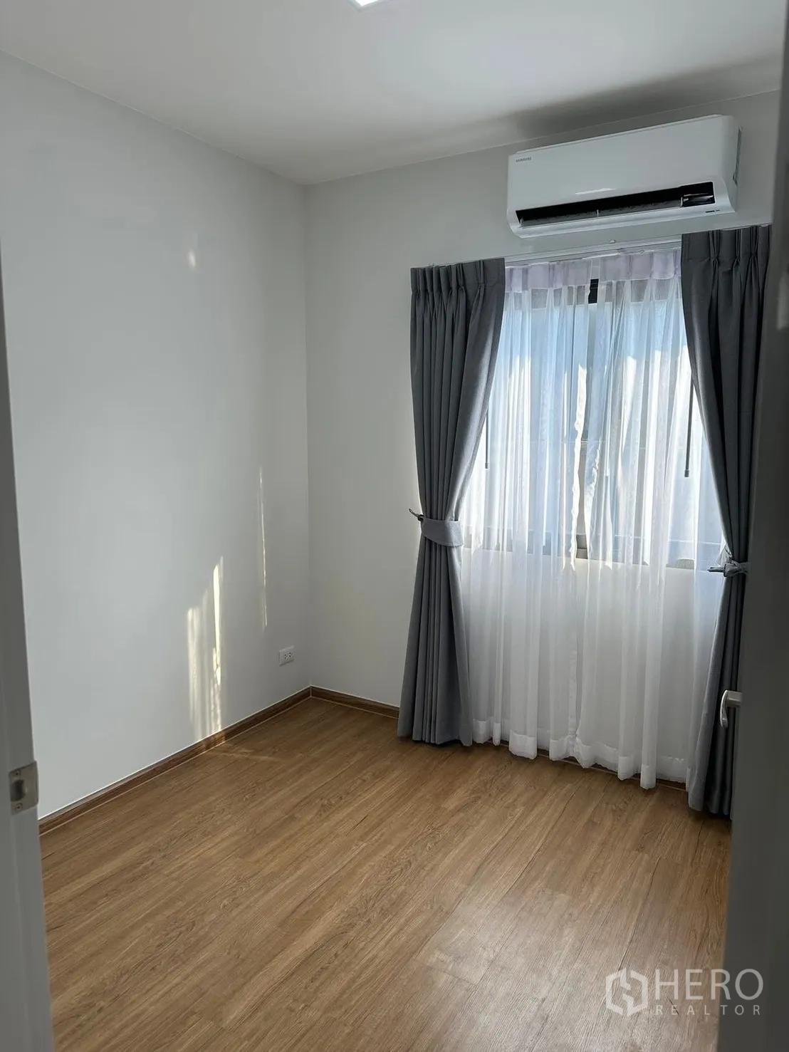 ทาวน์เฮาส์ for rent in Bang Phli, Samut Prakan - ห้องนอนโล่งพื้นไม้ หน้าต่างม่านโปร่งและทึบ พร้อมเครื่องปรับอากาศติดผนัง
