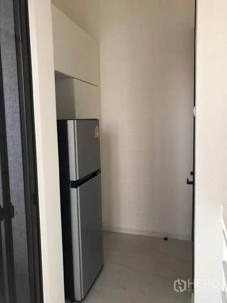 Condominium for sale in Ratchathewi, Bangkok - Tall refrigerator set in a pantry niche with overhead storage.