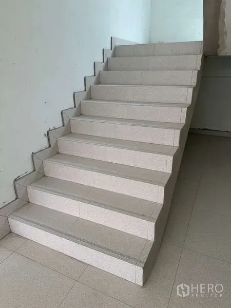 Home Office for sale in Bang Phli, Samut Prakan - Wide internal staircase with light-colored tiles connecting multiple levels.