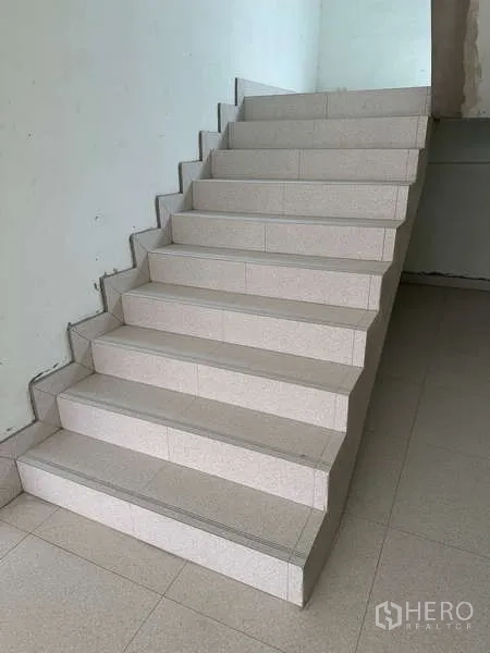Home Office for sale in Bang Phli, Samut Prakan - Wide internal staircase with light-colored tiles connecting multiple levels.