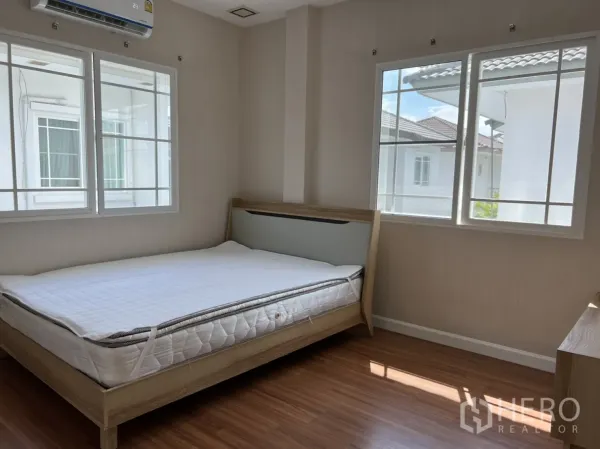 Detached House for rent in Bang Kapi, Bangkok - Corner bedroom with large windows, air‑conditioning, and warm wooden floors.