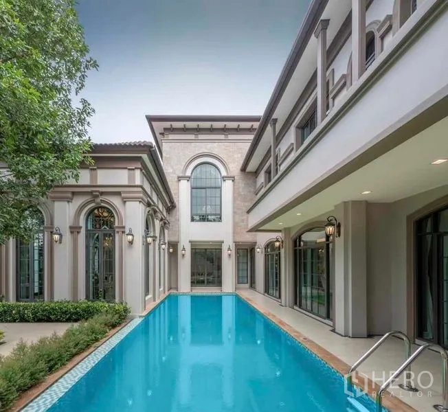 Detached House for rent or sale in Thawi Watthana, Bangkok - Private courtyard swimming pool framed by arched windows and greenery.