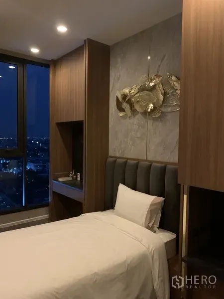 คอนโด ขายในPhra Khanong, Bangkok - ห้องนอนขนาดกะทัดรัด มีงานศิลป์เหนือหัวเตียงและมุมโต๊ะติดหน้าต่าง